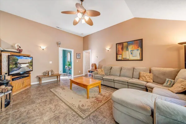 a living room with furniture a large window and a chandelier