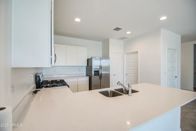 a kitchen with a refrigerator sink and cabinets