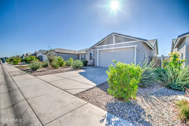 a front view of a house with a yard and potted plants