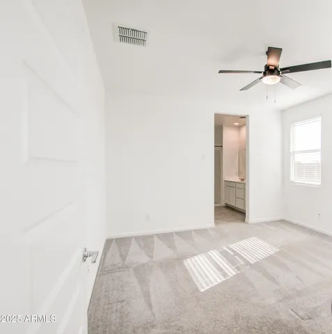 an empty room with windows and fan