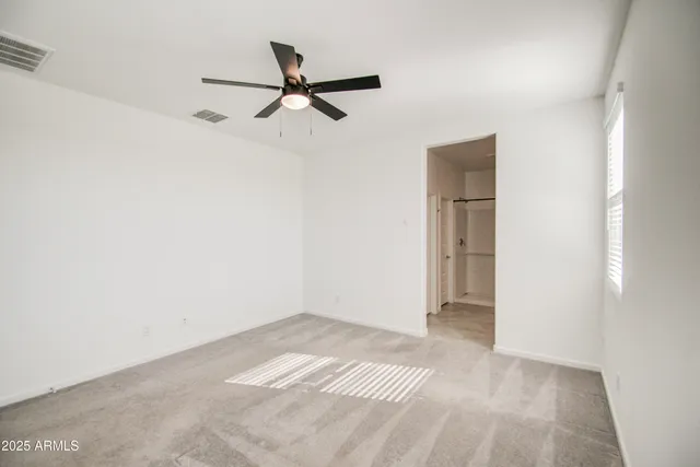 a view of a room with a ceiling fan and a window