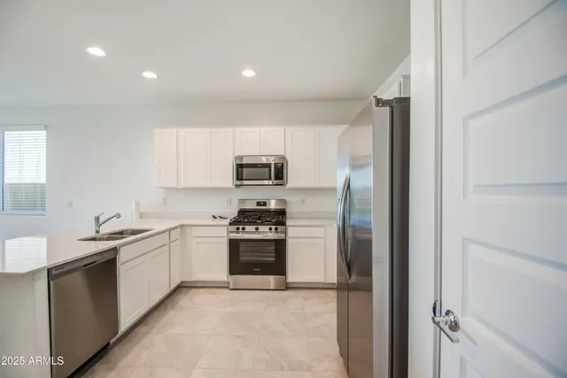 a kitchen with stainless steel appliances granite countertop a refrigerator and a sink