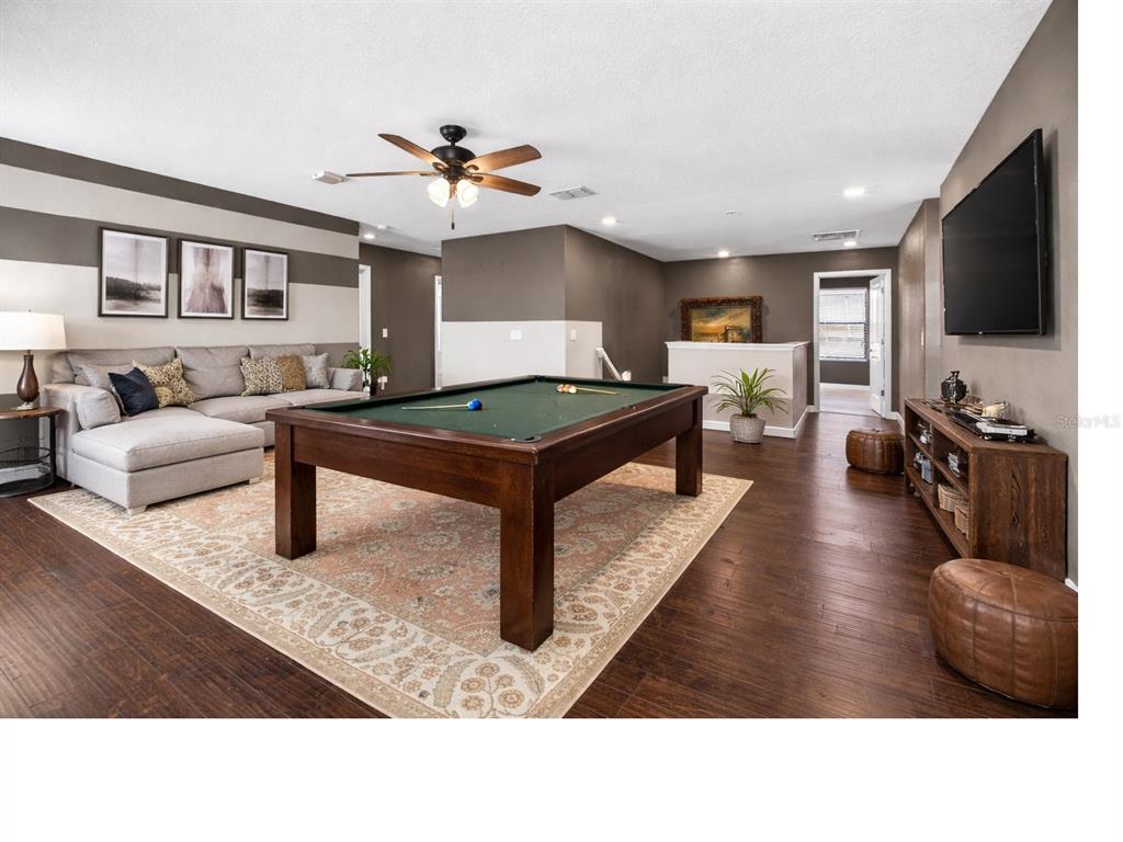 9906 Victory Gallop Loop Ruskin, FL 33573 - Photo 13 of 18 a living room with furniture a flat screen tv and kitchen view