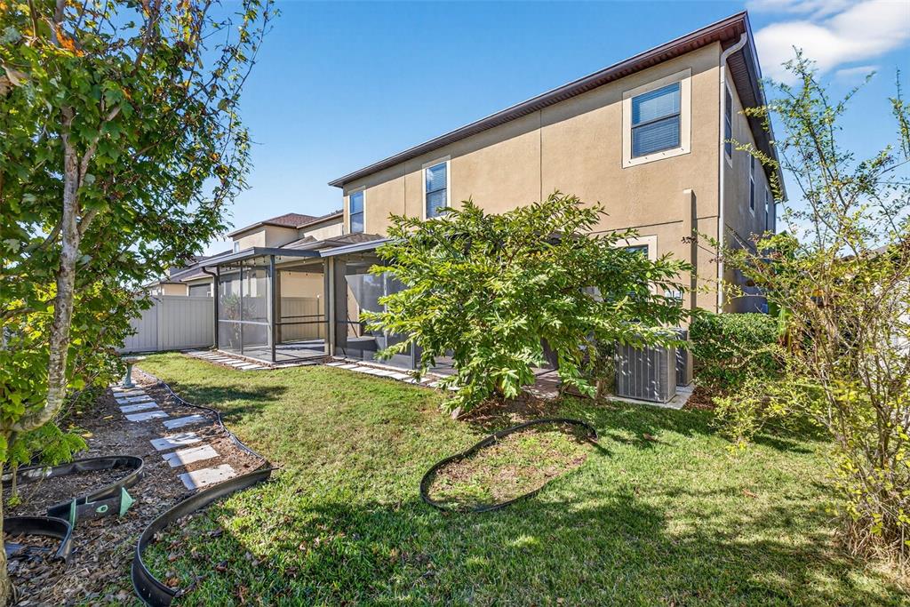 9906 Victory Gallop Loop Ruskin, FL 33573 - Photo 15 of 18 a backyard of a house with garden and plants