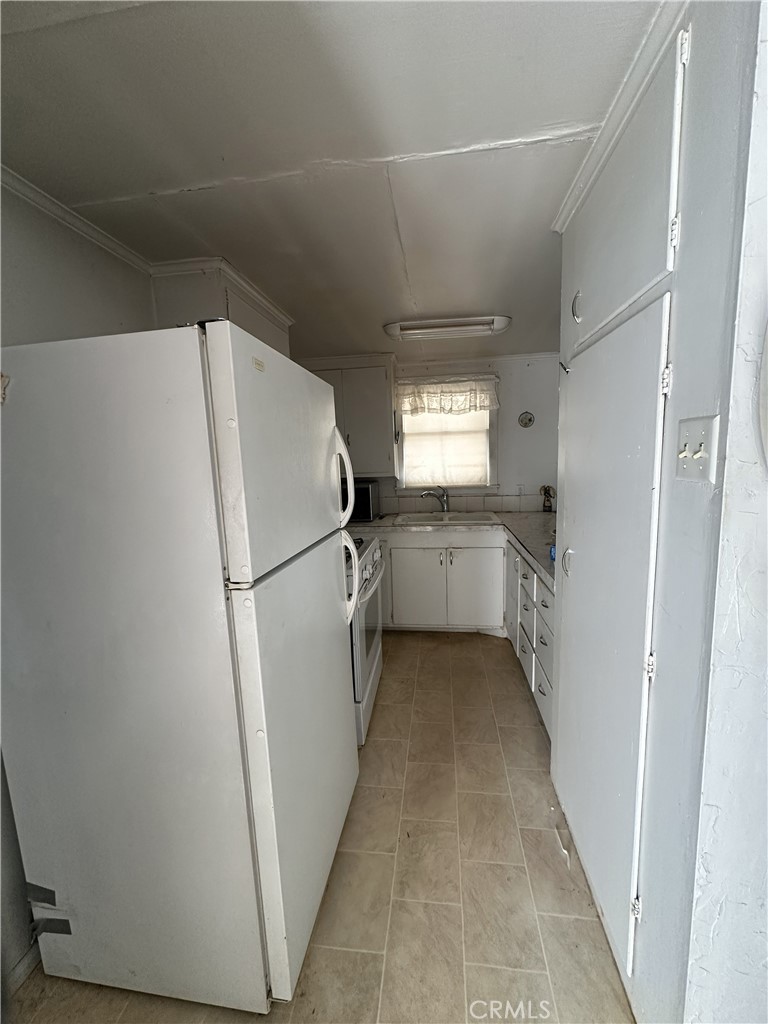 55710 Chaparral Road Yucca Valley, CA 92284 - Photo 9 of 18 a white refrigerator freezer sitting inside of a kitchen
