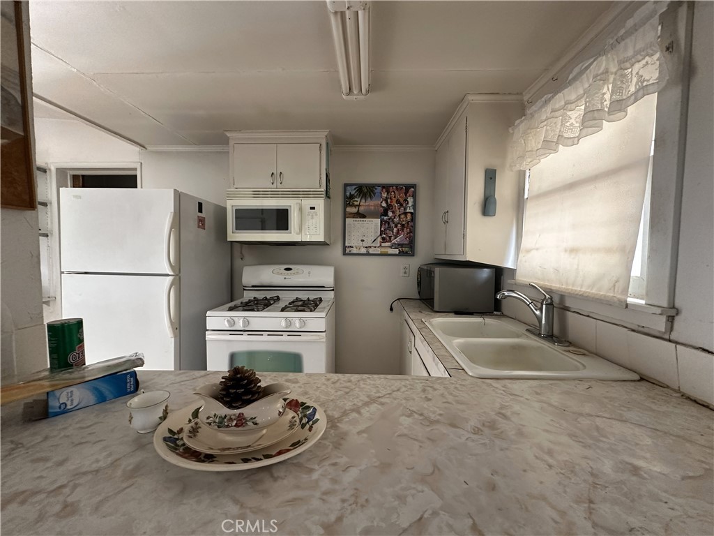 55710 Chaparral Road Yucca Valley, CA 92284 - Photo 10 of 18 a kitchen with a refrigerator and a stove