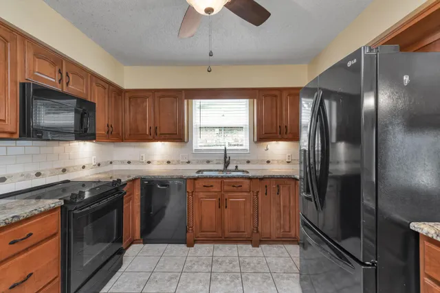 a kitchen with stainless steel appliances granite countertop refrigerator stove top oven and cabinets