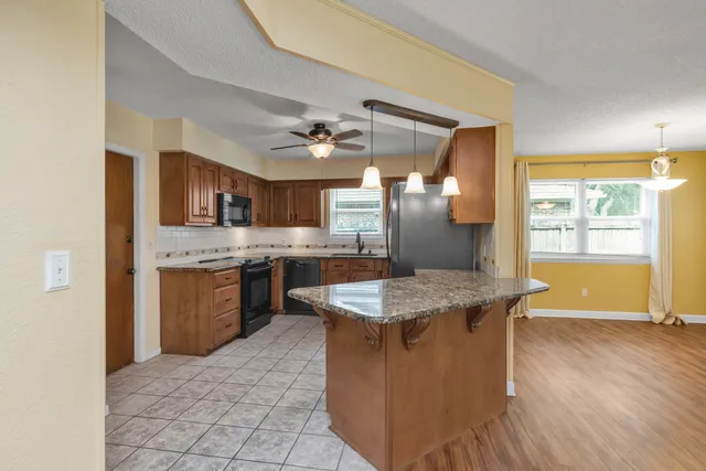 a kitchen with stainless steel appliances granite countertop wooden floors and view living room