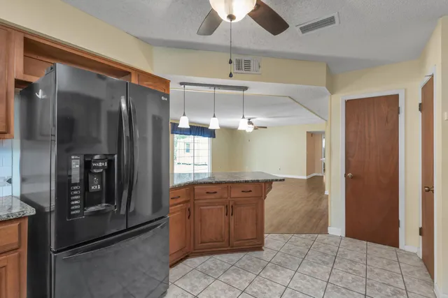 a kitchen with stainless steel appliances granite countertop a refrigerator and a sink