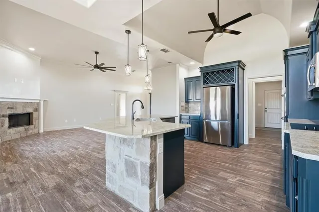 a kitchen with stainless steel appliances granite countertop a refrigerator a oven and a sink