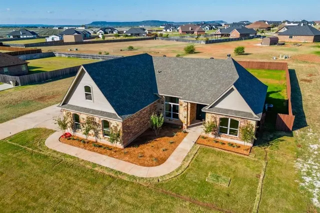 an aerial view of a house with swimming pool and ocean view