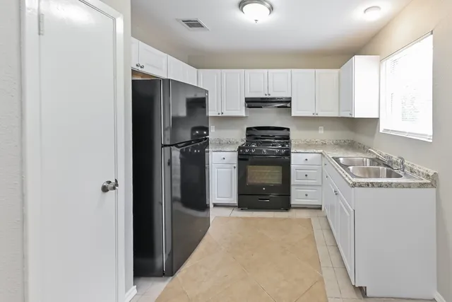 a kitchen with stainless steel appliances granite countertop a refrigerator stove and sink