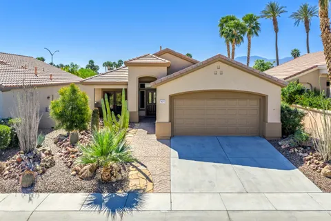 a front view of a house with a yard and potted plants