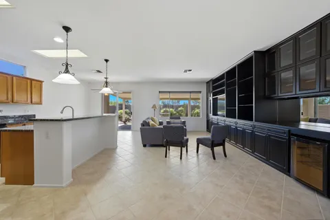 a living room with furniture windows and kitchen view