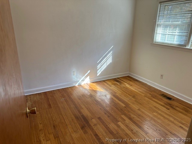 180 Castle Road Lumberton, NC 28358 - Photo 12 of 18 an empty room with wooden floor and windows