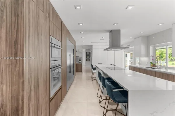 a large kitchen with stainless steel appliances a refrigerator and a stove top oven