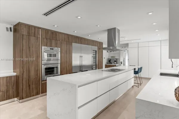 a large kitchen with a large counter top appliances and cabinets