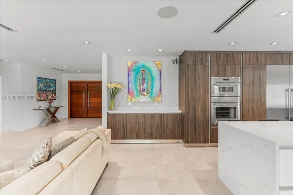 a kitchen with kitchen island a counter top space a sink stainless steel appliances and cabinets