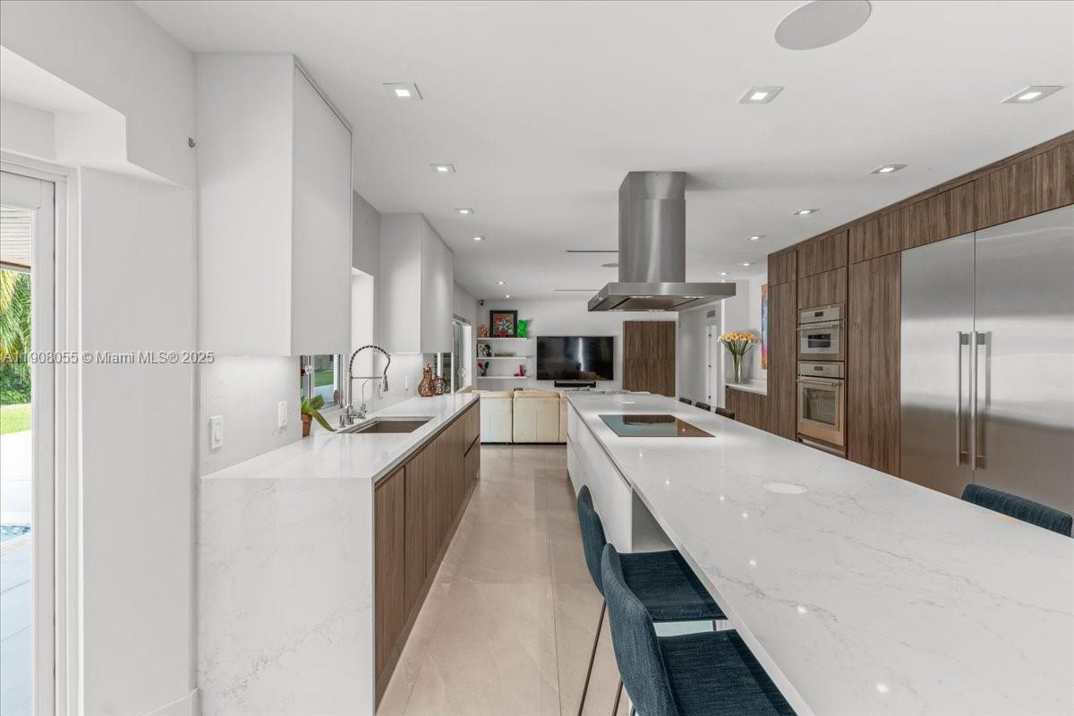 10105 Southwest 71st Avenue Pinecrest, FL 33156 - Photo 22 of 55 a large kitchen with a large counter top appliances and cabinets