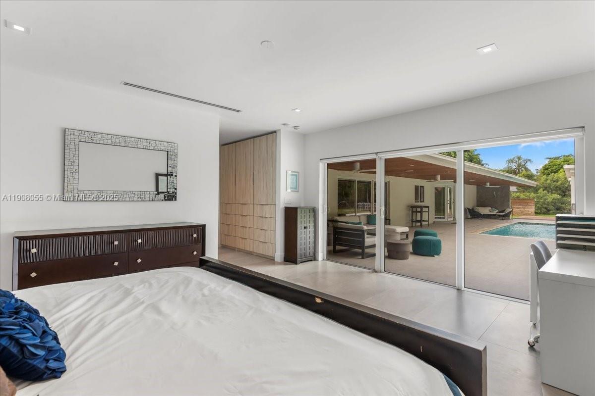 10105 Southwest 71st Avenue Pinecrest, FL 33156 - Photo 27 of 55 a bedroom with a bed and glass wall