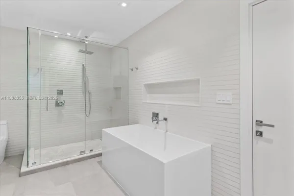 a spacious bathroom with a double vanity sink a mirror and a bathtub