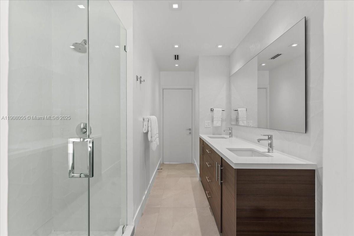 10105 Southwest 71st Avenue Pinecrest, FL 33156 - Photo 39 of 55 a bathroom with a double vanity sink mirror and shower