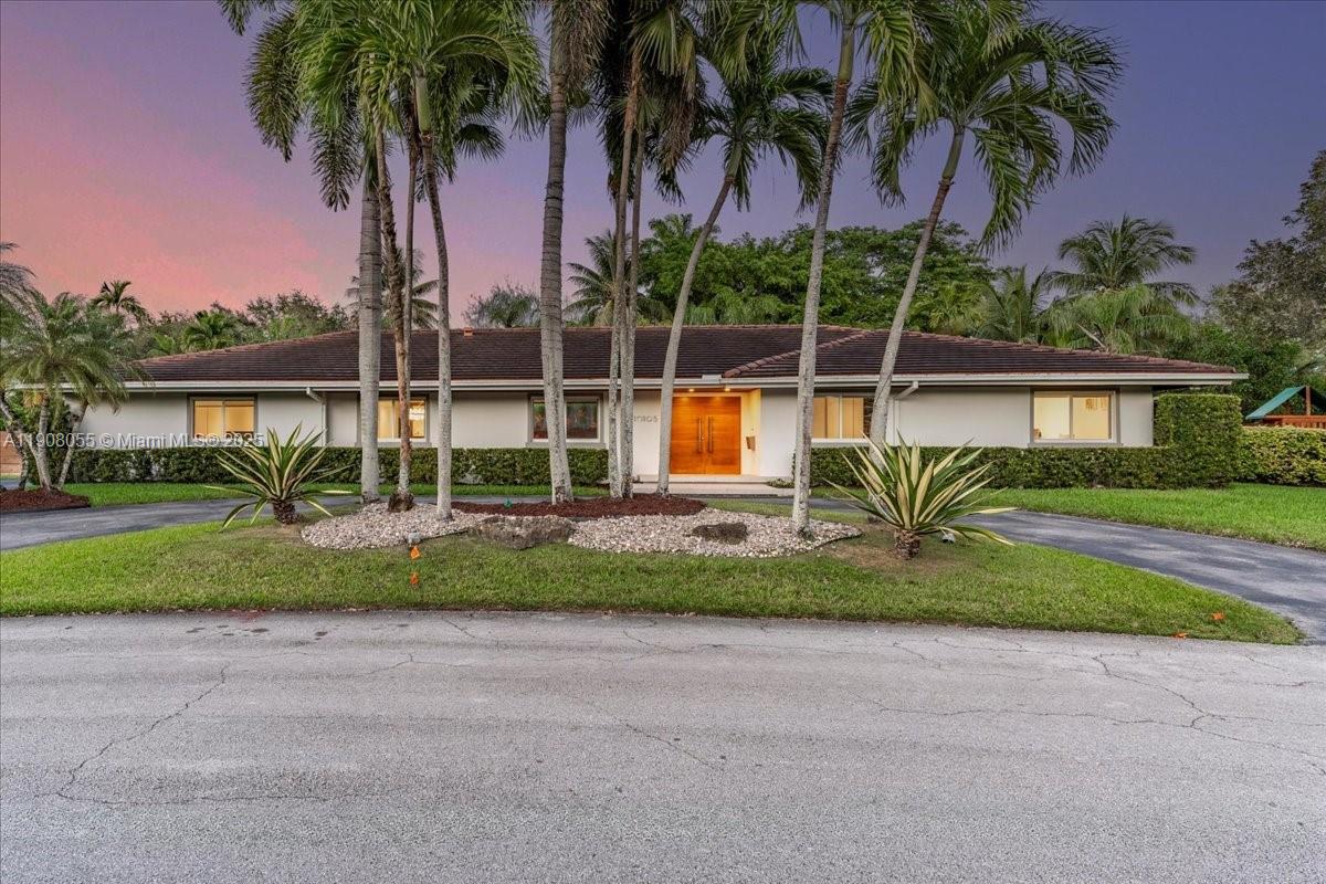10105 Southwest 71st Avenue Pinecrest, FL 33156 - Photo 51 of 55 a view of a house with a yard and palm trees