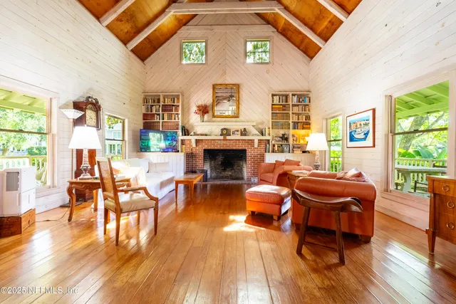 a living room with furniture a fireplace and wooden floor