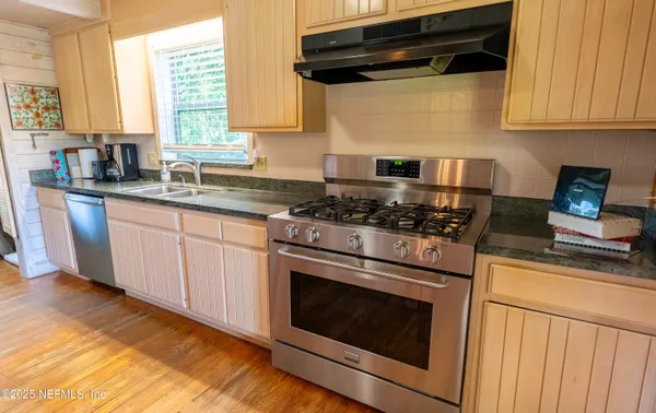 a kitchen with granite countertop cabinets stainless steel appliances and a window