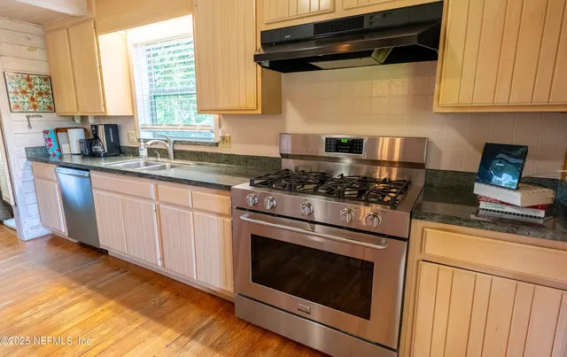 a kitchen with granite countertop cabinets stainless steel appliances and a window