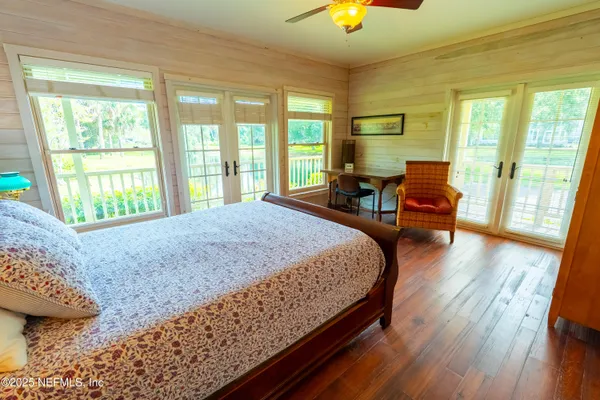 a bed sitting in a spacious bedroom next to a window