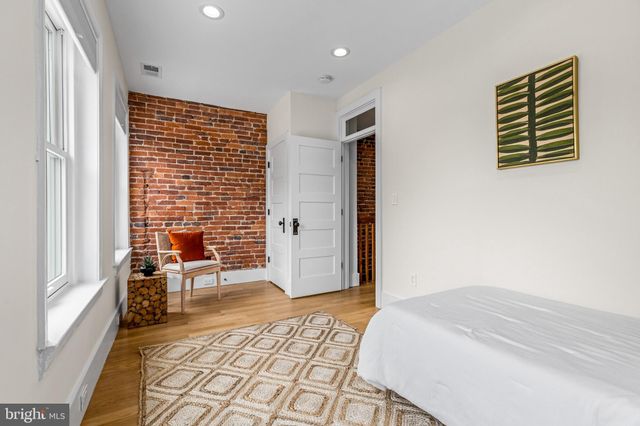 a view of an empty room with wooden floor and stairs