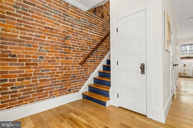 a bedroom with a bed a chair and potted plant on the table