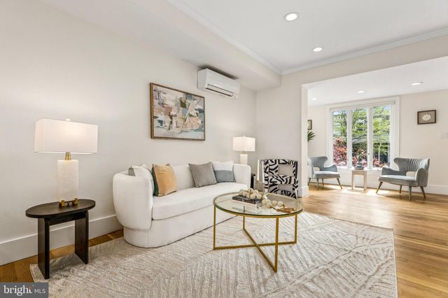 a living room with furniture a lamp on a table and a window