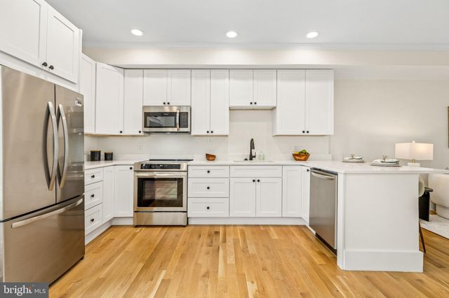a kitchen with a refrigerator stove and white cabinets