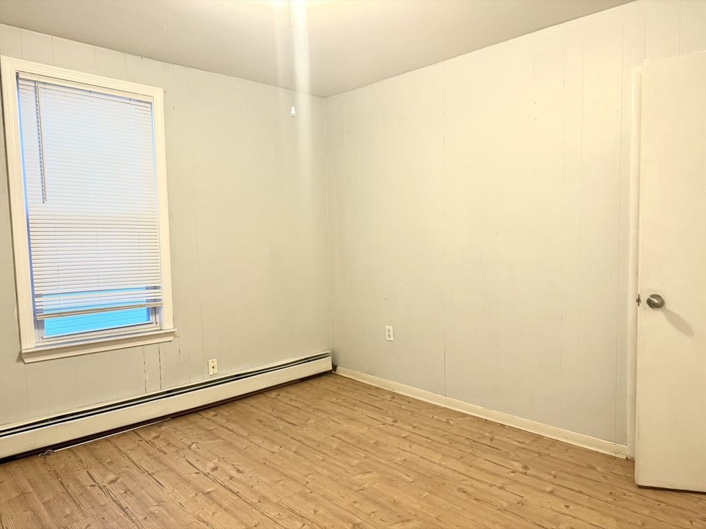 45 Mitchell Street, Unit 1 New Bedford, MA 02746 - Photo 11 of 11 a view of an empty room with wooden floor and a window