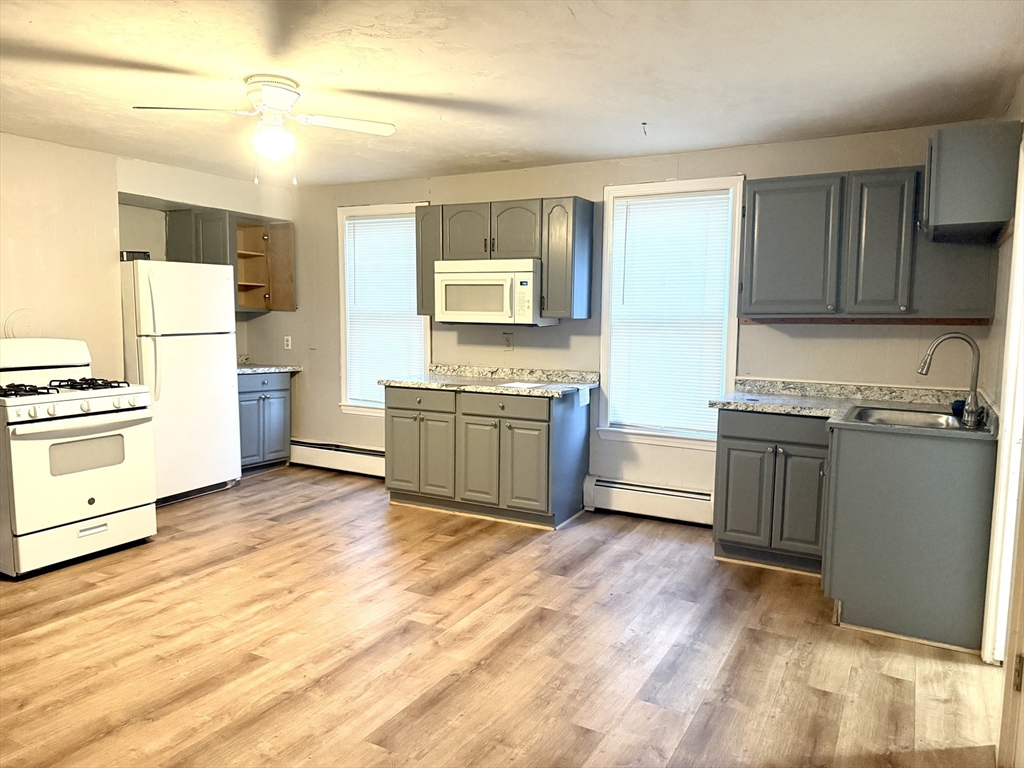 45 Mitchell Street, Unit 1 New Bedford, MA 02746 - Photo 5 of 11 a kitchen with a refrigerator and a stove top oven