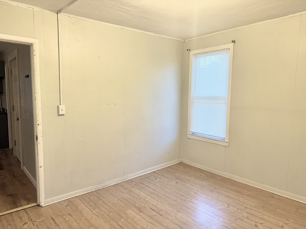 45 Mitchell Street, Unit 1 New Bedford, MA 02746 - Photo 9 of 11 an empty room with wooden floor and windows