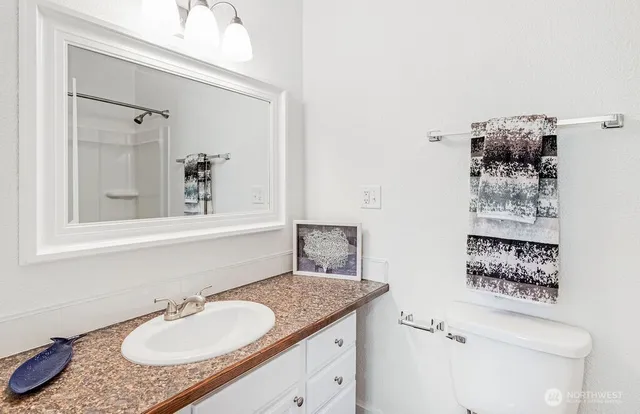 a bathroom with a granite countertop sink and a mirror