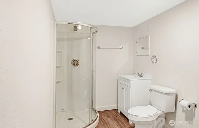 a bathroom with a granite countertop toilet a sink a shower and a mirror