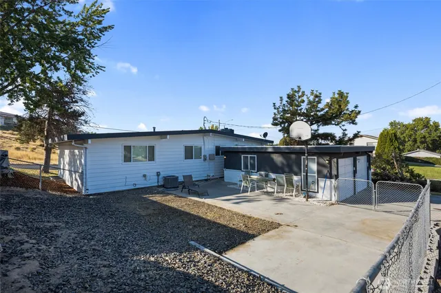 a view of a house with backyard and sitting area