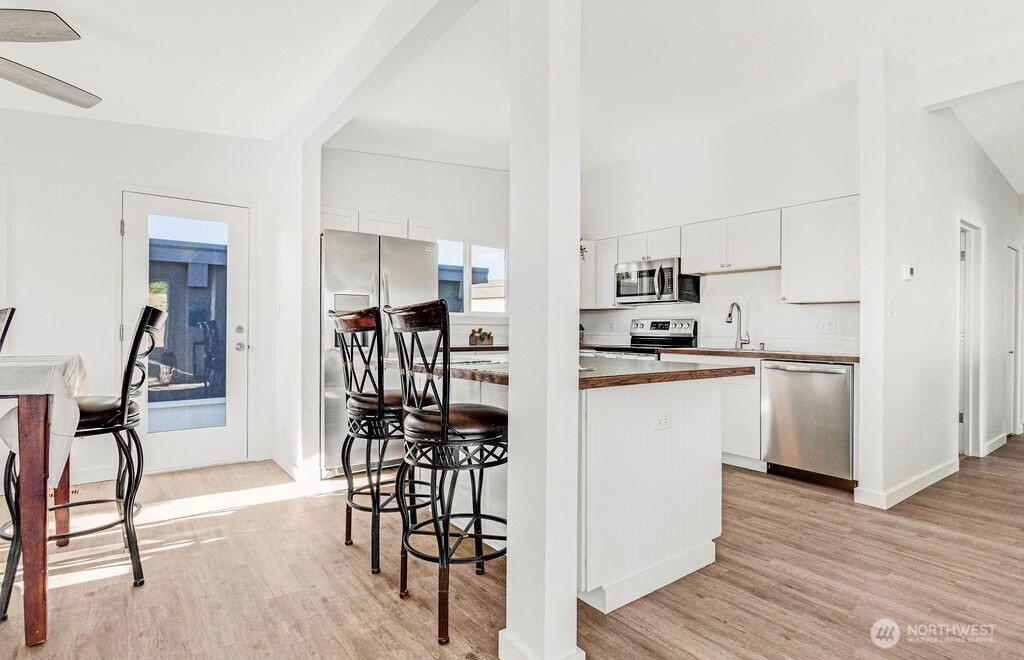 128 West Nelson Road Moses Lake, WA 98837 - Photo 7 of 37 a kitchen with stainless steel appliances a refrigerator and a stove top oven