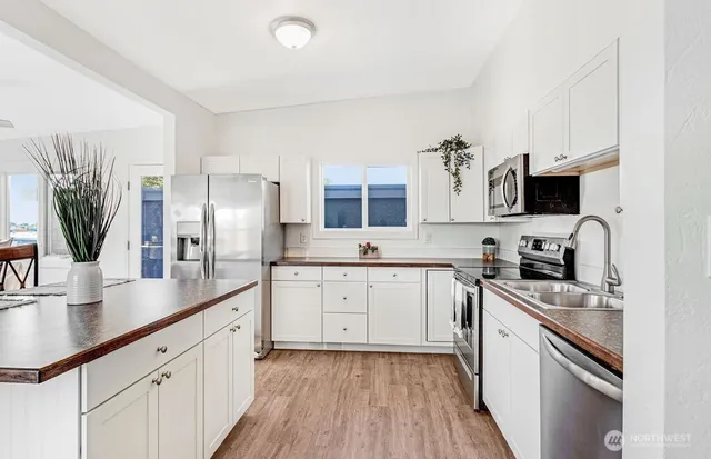 a kitchen with granite countertop a sink stove and refrigerator