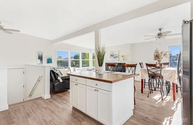 a kitchen with a sink a stove cabinets and wooden floor