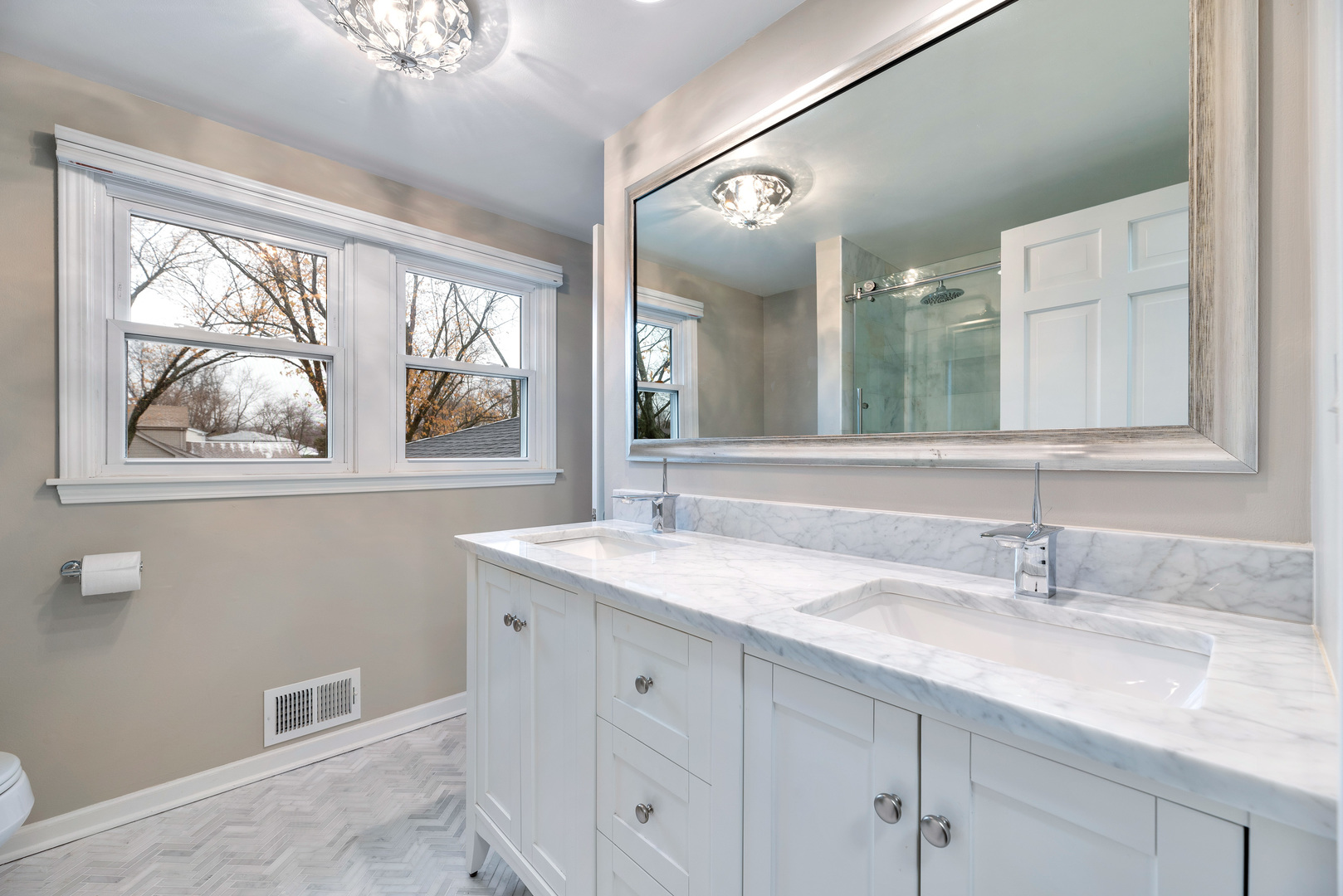 3231 Maple Leaf Drive Glenview, IL 60026 - Photo 12 of 36 a bathroom with a granite countertop sink a large mirror and a window