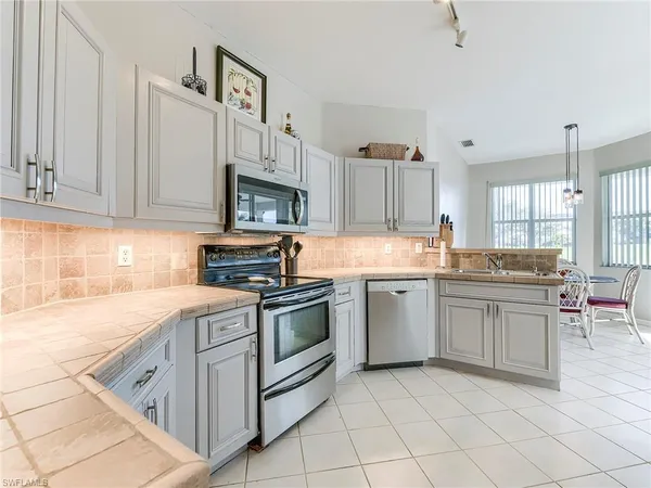 a kitchen with granite countertop cabinets stainless steel appliances and a counter space