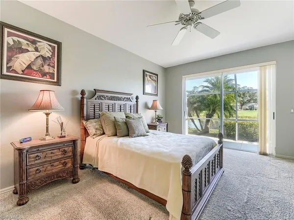 a bedroom with a bed a large window and a chandelier