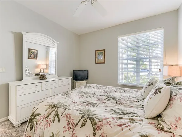 a bed sitting in a bedroom next to a window and dresser