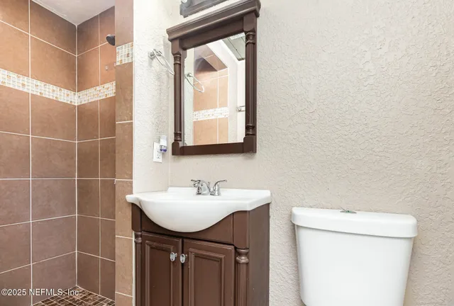 a bathroom with a sink a toilet and a mirror