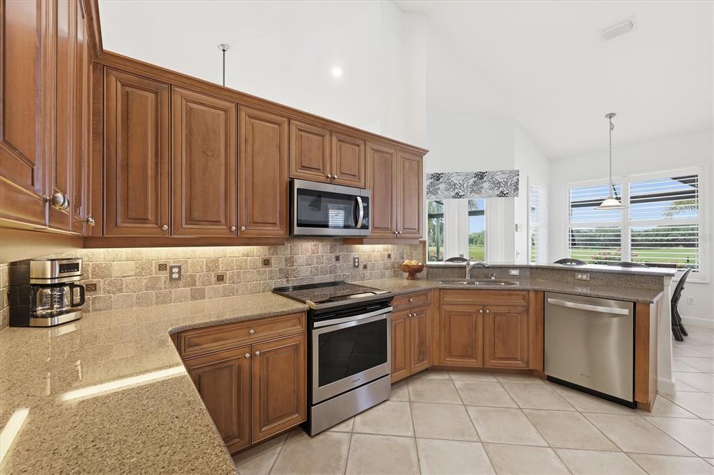 3606 Pennyroyal Road Port Charlotte, FL 33953 - Photo 28 of 96 a kitchen with stainless steel appliances granite countertop a stove a sink and a microwave
